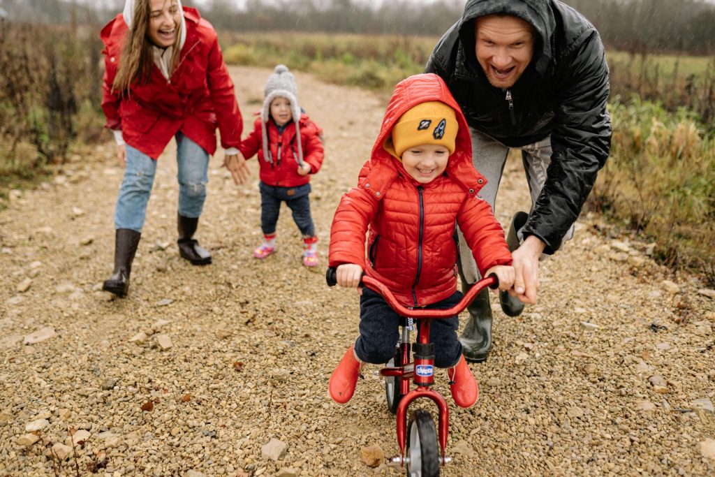 Parents helping child learn to ride a bike. Helping anxious children understand what they can control.