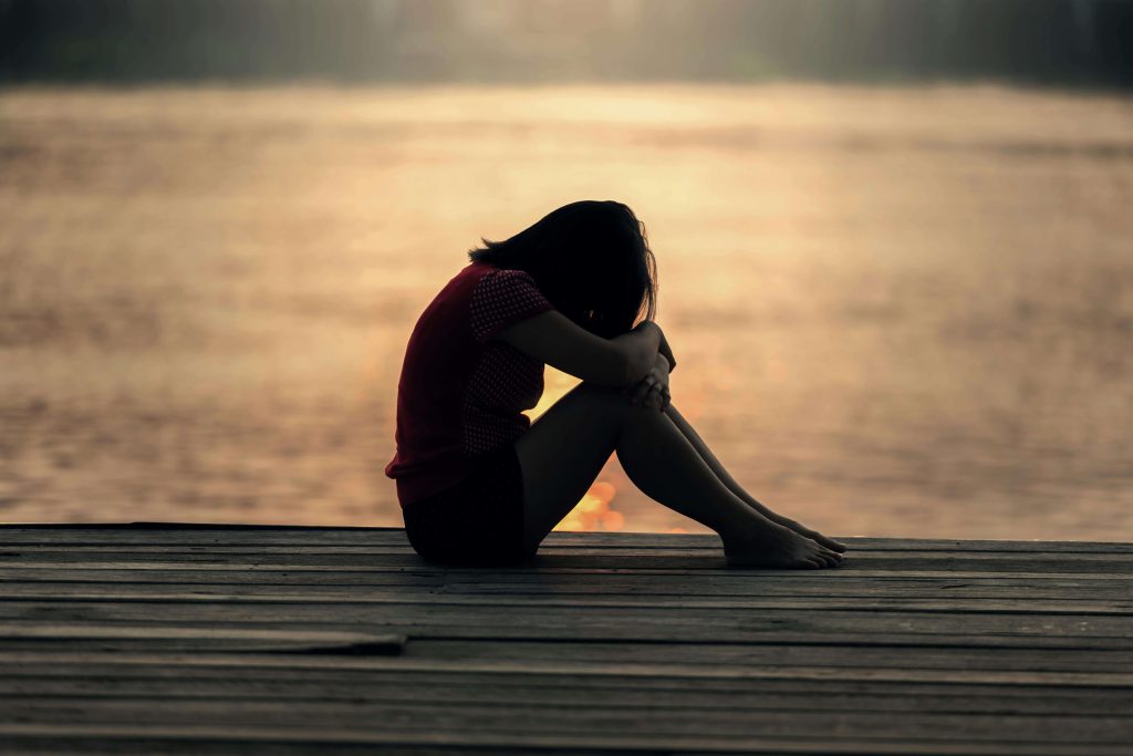 Anxious girl sitting by the water. Helping anxious children understand what they can control.