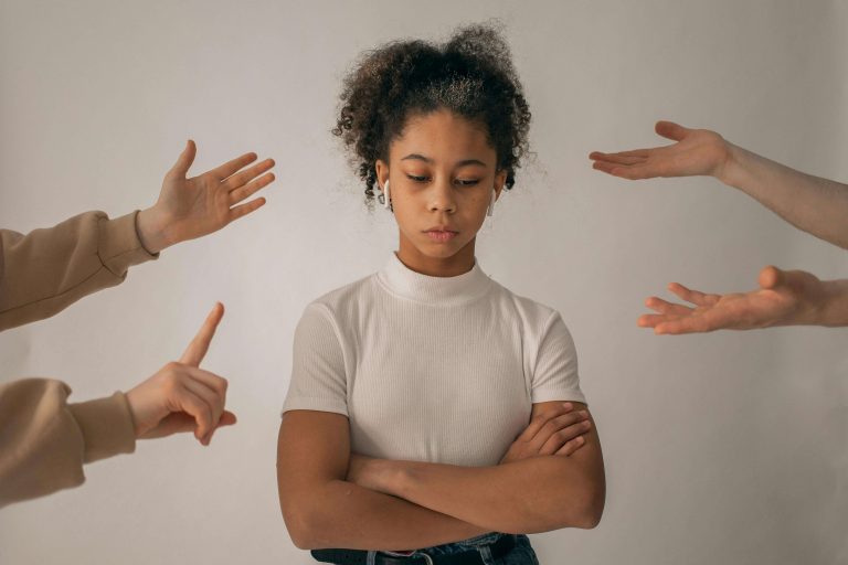 Teen girl with anxiety. Hands reaching towards her indicating overwhelm. Tips for Helping children work through their anxiety. Brain Insights.